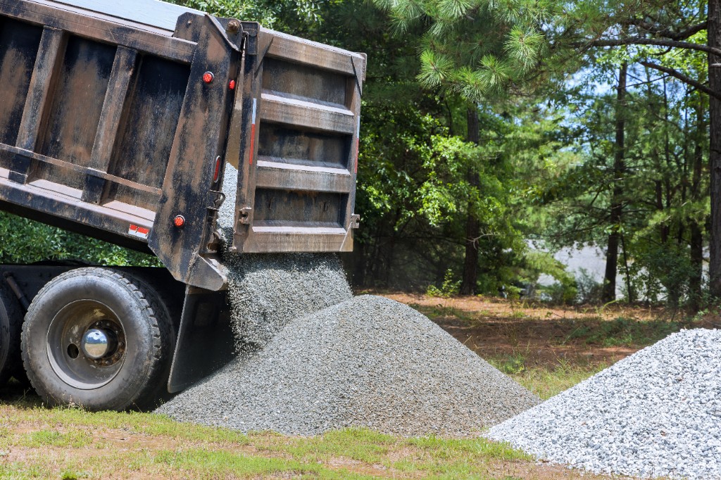 Dump truck unloading crushed stone for driveway or road base