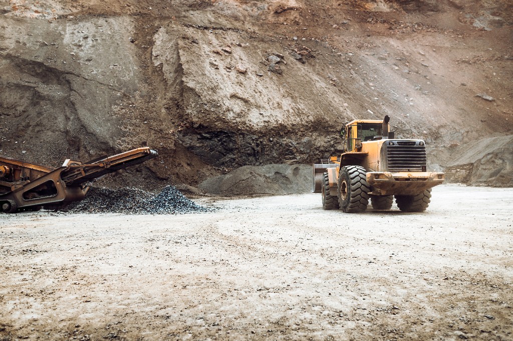 Pit loading area with loader and aggregate stockpiles